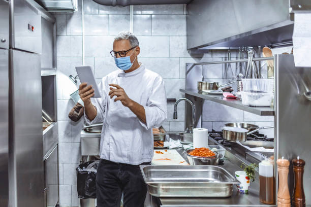 istock Mature chef using digital tablet and controlling the stock 1307162984