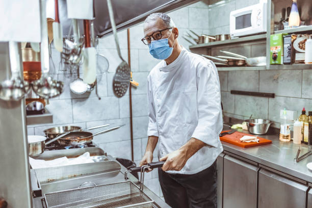 istock Chef working in a commercial kitchen, preparing deep-fried food 1307163020
