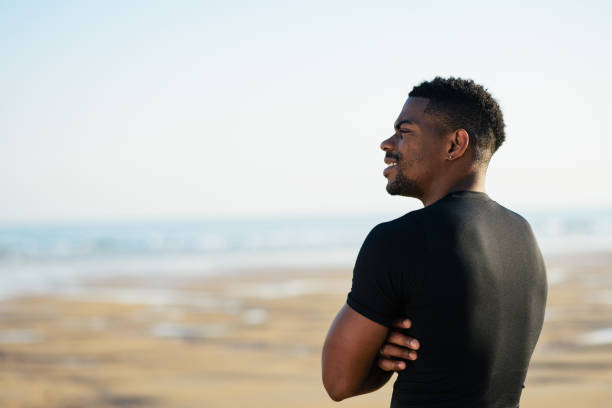 istock Black motivated man after running at the beach 1307163195