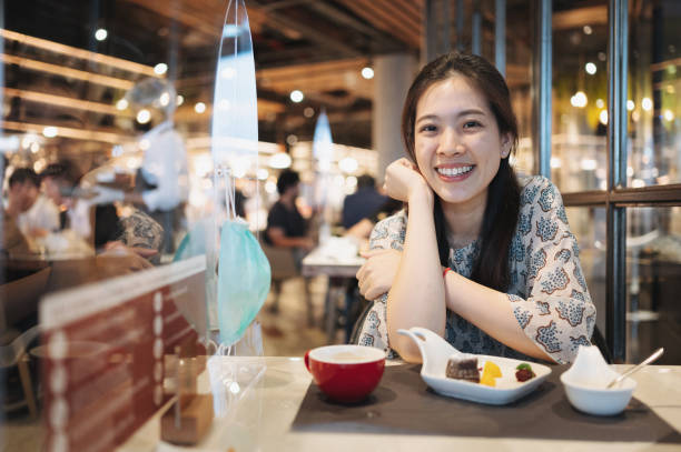 istock Cheerful asian enjoy dessert cafe with new normal concept PPE plastic protect covid-19 pandermic social distancing concept 1307165064
