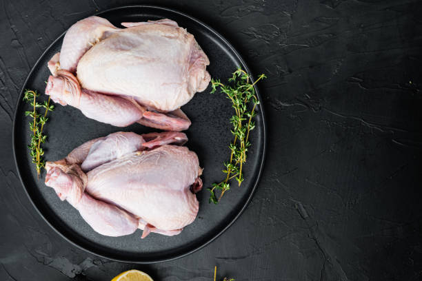 istock Raw coquelet chickens with herbs spices ingredients, on black background, top view with copy space for text 1307168599