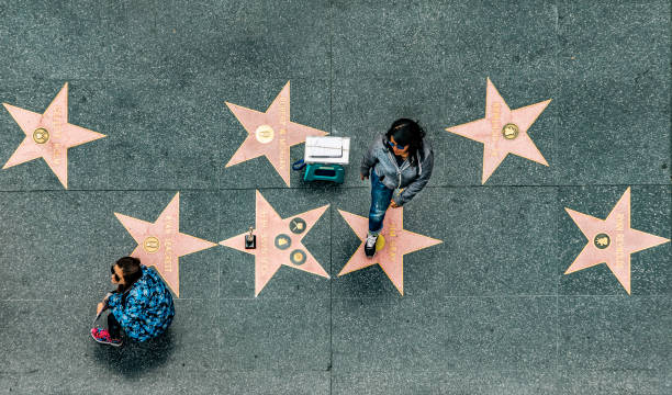 aerial of walk of fame with tourists looking for stars and actors Los Angeles, USA - March 5, 2019: aerial of walk of fame with tourists looking for stars and actors earning money by posing for movie figures. hollywood california stock pictures, royalty-free photos & images