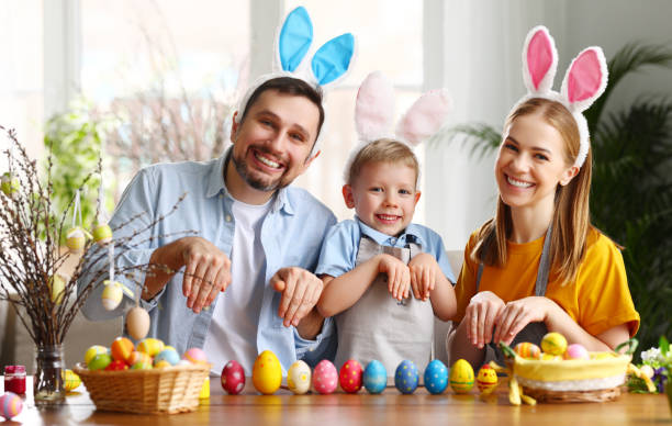 istock Family in bunny ears and with painted Easter eggs at home 1307181452
