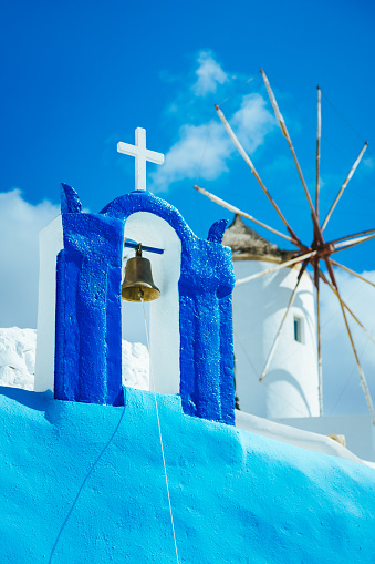 Top of Orthodox church with cross and bell on Santorini island, Greece.