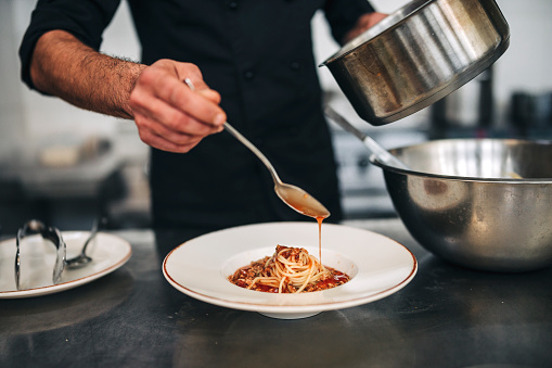 Professional Male chef hand prepare fresh pasta in commercial kitchen