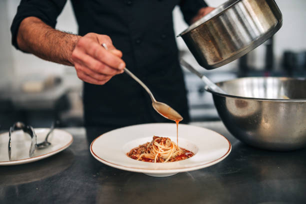 Male chef prepare pasta in restaurants kitchen stock photo