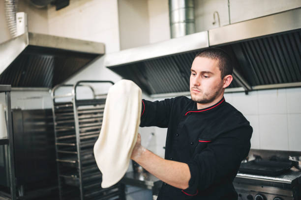istock Male Chef preparing a pizza in the kitchen 1307182271