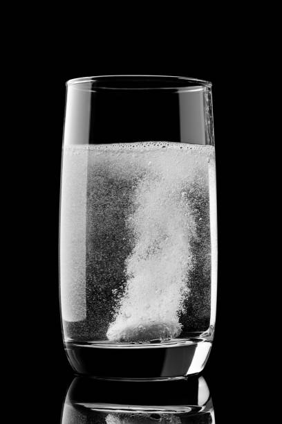 effervescent tablet with vitamins dissolves in a glass of water stock photo