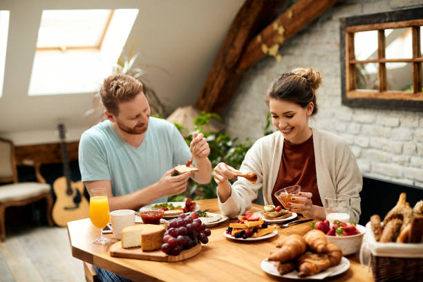 istock Young happy couple enjoying in breakfast at dining table at home. 1307182734