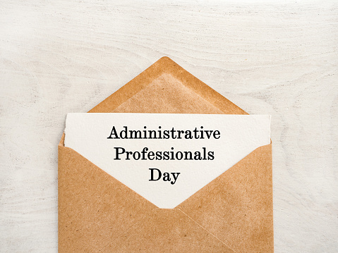 Admin Day Greeting Card. Close-up, view from above, wooden surface. Concept of preparation for a professional holiday. Congratulations for relatives, friends and colleagues