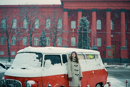 Woman  standing near the van in winter in the city