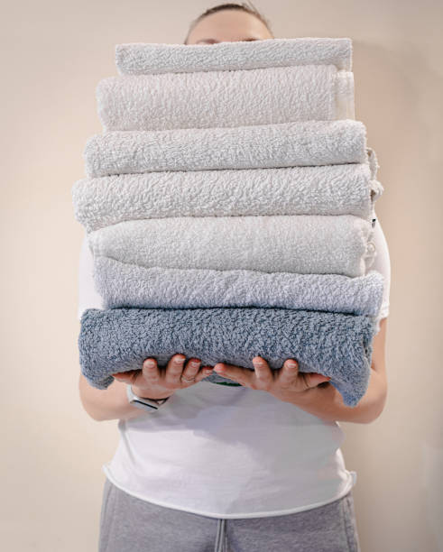 istock Woman holding a stack of towels 1307184571