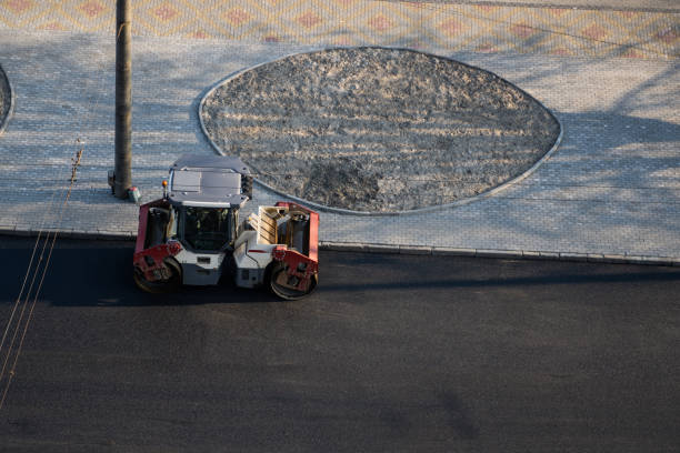 Asphalt road roller with heavy vibration roller compactor press new hot asphalt on the roadway on a road construction site. Heavy Vibration roller at asphalt pavement working. Repairing