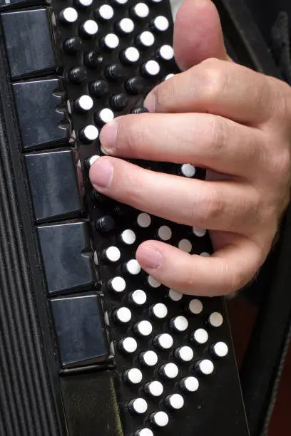 Accordion player's left hand on the accordion keyboard