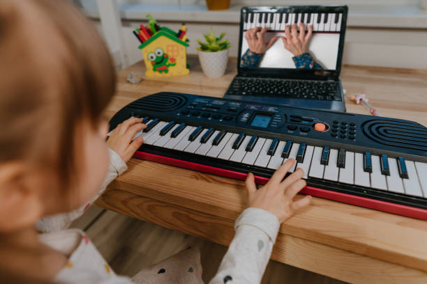 istock Little girl watching online lesson tutorial how to learn a synthesizer 1307187835