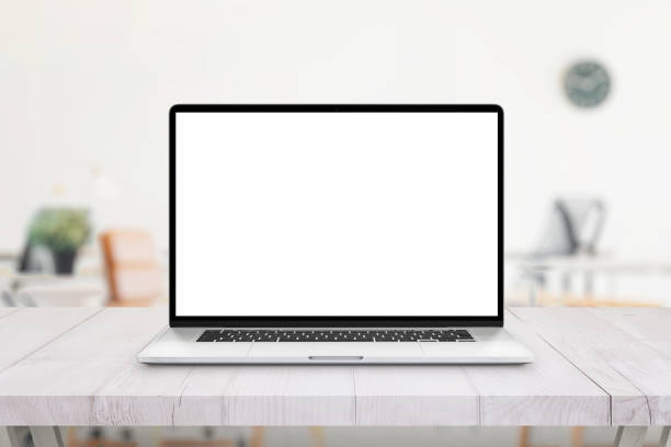 istock Laptop on office desk. Isolated screen for mockup, app or web site presentation. Clean white wooden desk. Office in bacgkround 1307187913