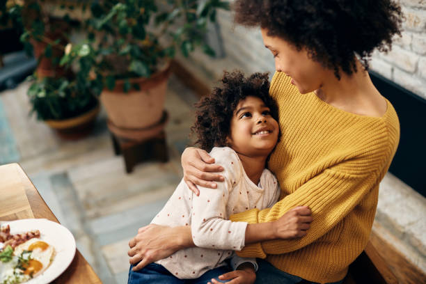 istock African American mother and daughter embracing while talking at home. 1307187964