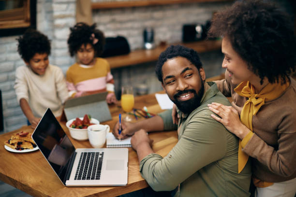 istock Happy black man talking to his wife while working at home. 1307187987