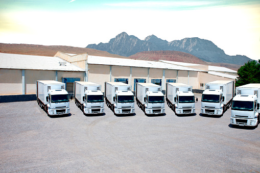 White Freight trucks trailers at logistics warehouse loading docks