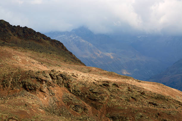 on top of a mountain with a cloudy sky