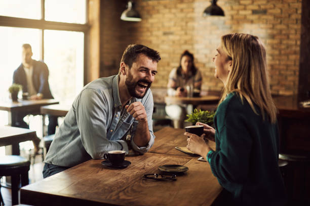 istock Cheerful couple laughing while talking about something funny in a cafe. 1307190646