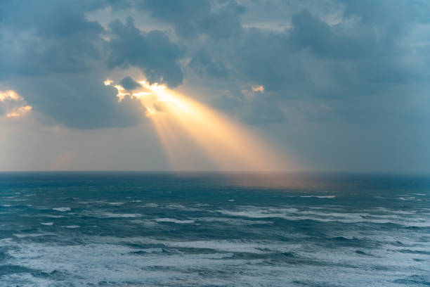 raggi d'oro del sole che sfondano le nuvole della tempesta - gods rays foto e immagini stock