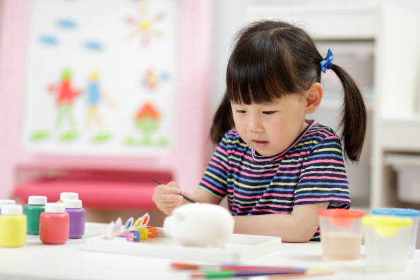 istock Cute Girl Learning Painting At School 1307192459