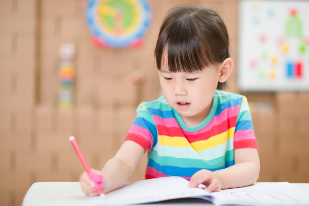 istock Cute Girl Writing In Book At Home 1307192497