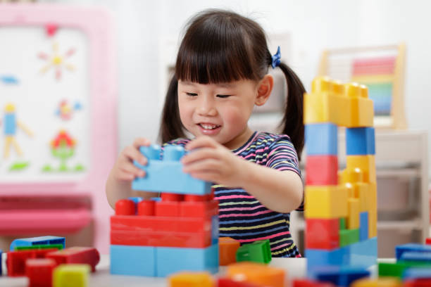 istock Cute Girl Playing With Building Blocks At Classroom 1307192520