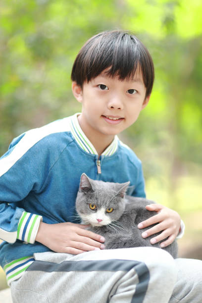 Small boy with messy hair holding his pet -cat