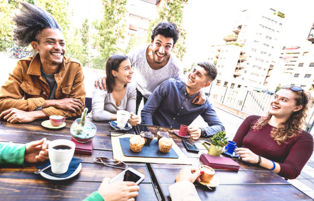 istock People group drinking cappuccino at coffee bar restaurant - Friends talking and having fun together at outdoors cafeteria - Life style concept with happy men and women at cafe - Warm bright filter 1307197058