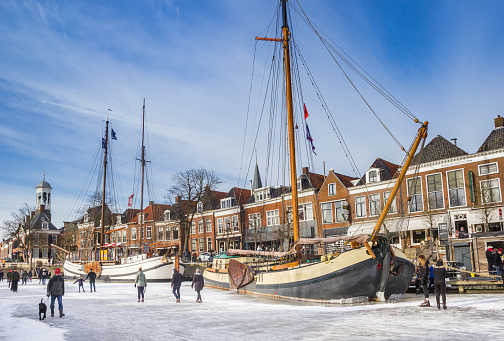 Historic wooden sailing ships in the frozen canal of Dokkum, Netherlands