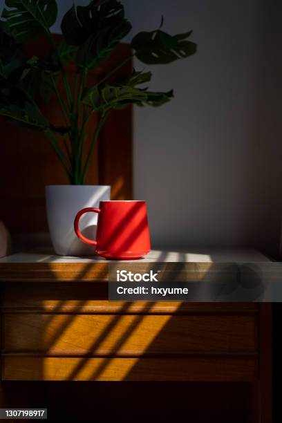 Red Coffee Mug On Top Of A Night Stand Stock Photo - Download Image Now - Night Table, Sunbeam, Cup