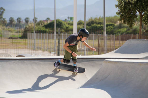 nastoletni chłopiec w skateparku przed błękitnym niebem - skateboard park zdjęcia i obrazy z banku zdjęć