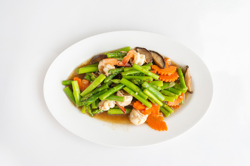 Stir-Fried Mixed vegetable asparagus, mushroom, and shrimp, on a white table Thai local food, Close-up top view.