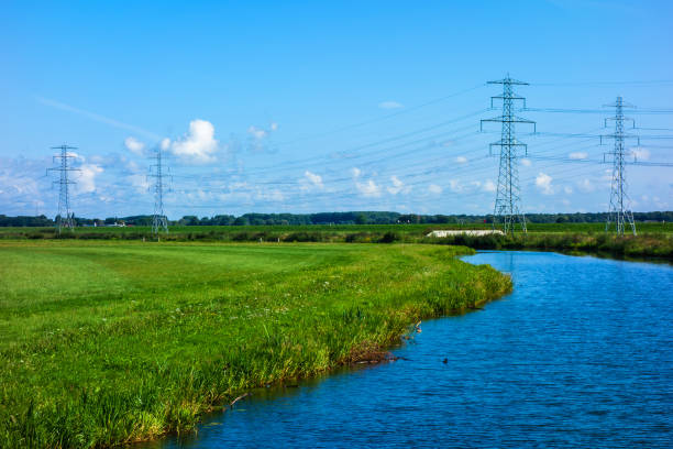 istock Landscape with river and meadows and power pylons 1307202948