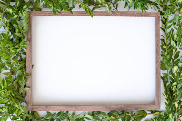 istock Top view : wooden frame with empty space and light green leaves background. 1307203183