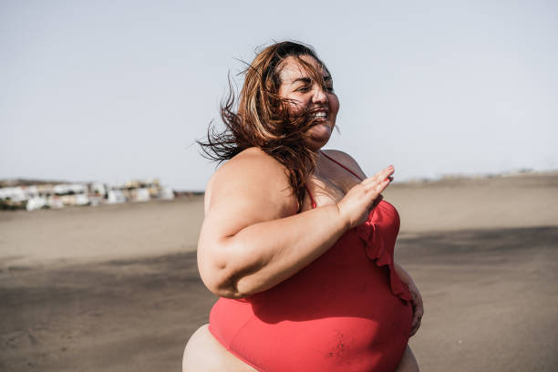 istock Plus size woman having fun on the beach on summer vacation - Focus on face 1307206480