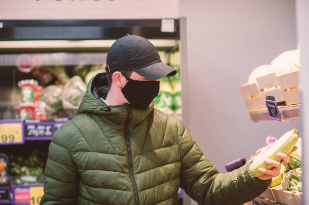 istock A young man wearing a protective mask in a supermarket 1307206832
