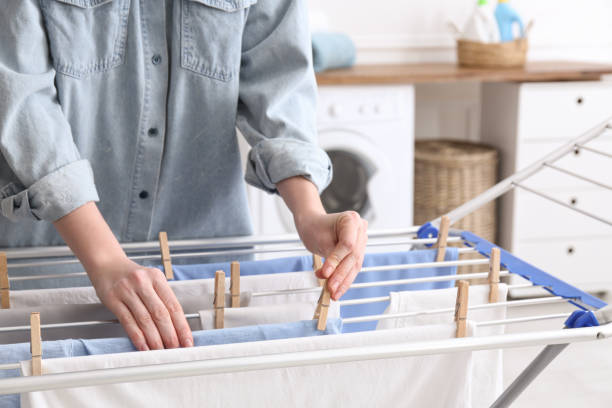 woman hanging clean laundry on drying rack in bathroom, closeup - secar imagens e fotografias de stock