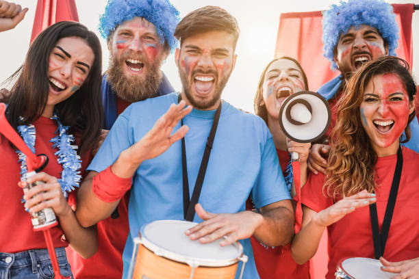 istock Crazy sport fans playing drums and screaming while supporting their team 1307209617