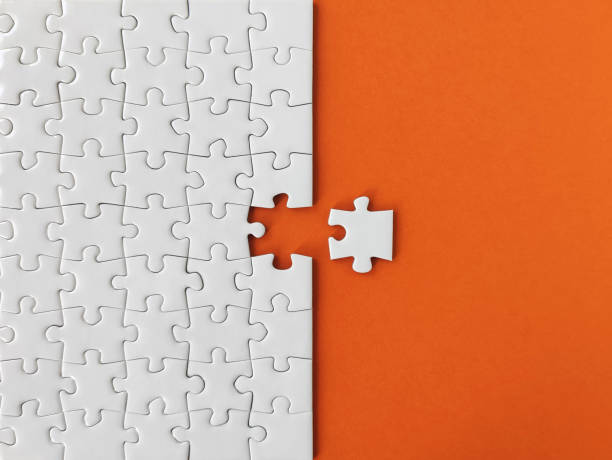 istock Missing piece of the puzzle, white puzzle pieces on orange background 1307210720