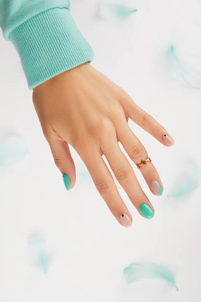 istock Womans hand with trendy turquoise manicure with copy space 1307210911