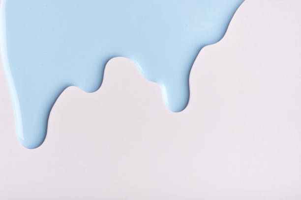 istock Light blue liquid drops of paint color flow down on isolated white background. Abstract backdrop with fluid drip pattern 1307213044