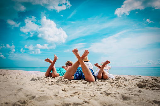 father with son and daughter relax on beach, family vacation