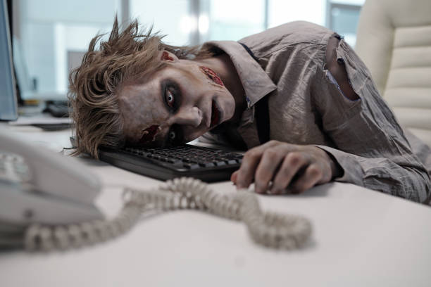 uomo d'affari morto con la pittura del corpo zombie che tiene la testa sulla tastiera del computer dopo aver lavorato - frustration telephone computer it support foto e immagini stock