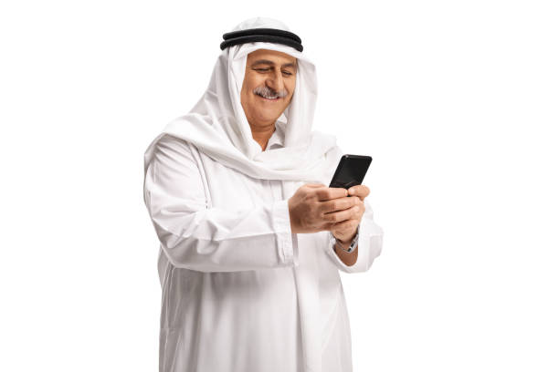 istock Mature arab man smiling and using a mobile phone 1307215051