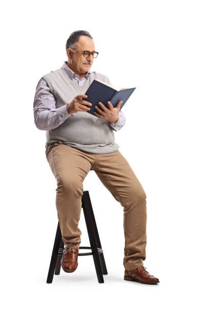 istock Mature man reading a book seated on a high chair 1307215088