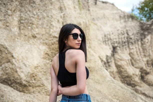istock young female model posing and resting outside in sand quarry 1307216019