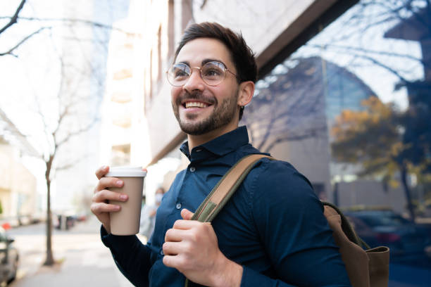 istock Young man holding a cup of coffee while walking outdoors. 1307216314